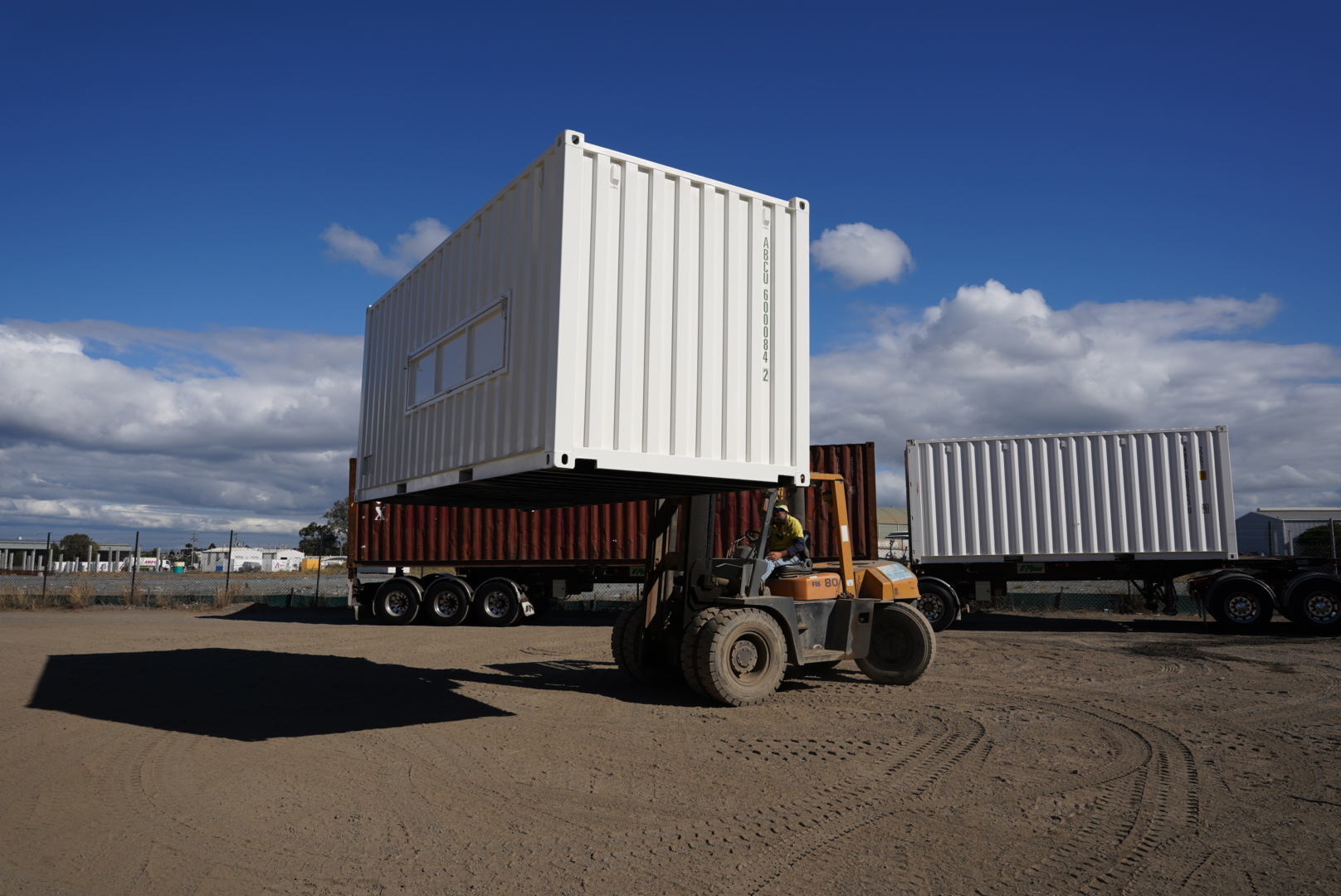 A shipping container being lifted by a forklift at our Brisbane depot